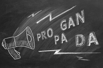 Propaganda and fake news concept. Illustration on blackboard. A megaphone with the word propaganda. Misinformation and counterinformation concept.