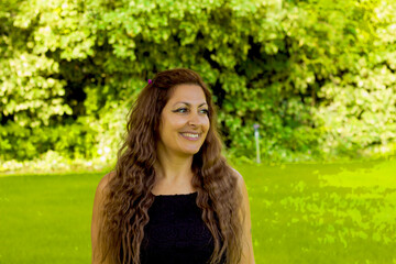Naklejka premium portrait of a beautiful woman in the green garden with flowers