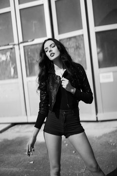 beautiful slim girl in shorts and cigarette. black and white photos