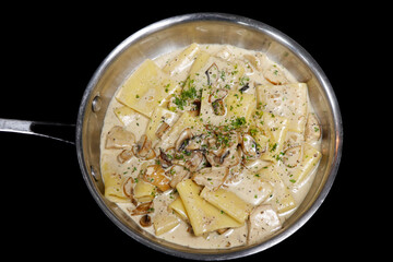 traditional italian creamy wild mushroom pasta with truffle, ceps and porchini, black background