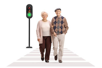 Full length portrait of an elderly couple walking across street and holding arms