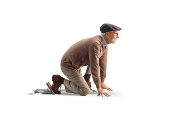 Full length profile shot of an elderly man kneeling on starting blocks © Ljupco Smokovski