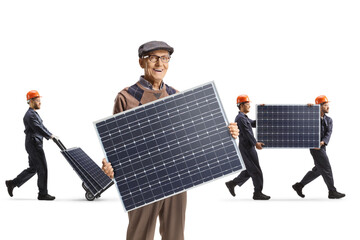 Elderly man holding a photovoltaic panel and workers carrying panels in the back