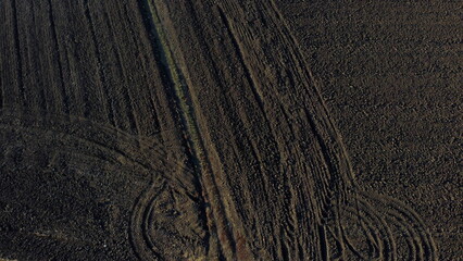 Landscape of plowed up land on an agricultural field on a sunny autumn day. Flying over the plowed earth with black soil. Black soil. Ground earth dirt priming aerial drone view. Agrarian background