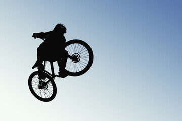 Fototapeta na wymiar Skyward Bound: A Cyclist in Silhouette