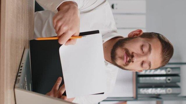 Business man reading business contract, planning project, analyzing resume, shakes finger, saying No, unsatisfied, disagree, candidate with failure at office talking, online interview. Vertical shot