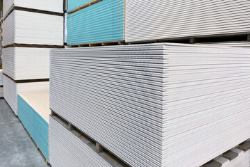 The large stack of Special gypsum board with enhanced sound insulation Plasterboard. Panel Type A for indoor concrete walls prepared for construction in hardware stores.