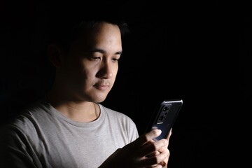 Young Asian man using and looking at a smartphone