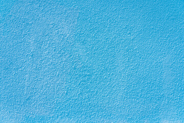 Fototapeta na wymiar Rough textural surface of a blue wall. Background or backdrop. Blank for design