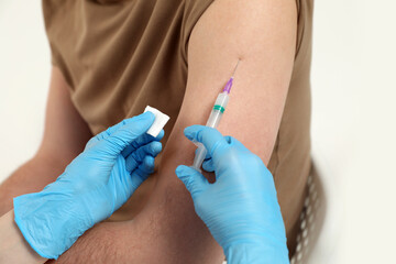 Doctor giving hepatitis vaccine to patient on white background, closeup