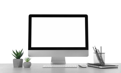 Computer, potted plants and stationery on table against white background. Stylish workplace