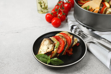 Delicious ratatouille served with basil on light grey table. Space for text
