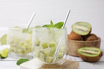 Refreshing drink with kiwi and mint on white table, closeup