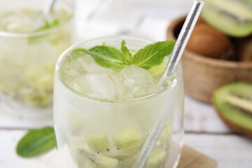 Refreshing drink with kiwi and mint on white table, closeup
