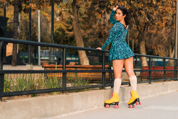 retrato de bella mujer latina posando con patines estilo 80s 90s con vestido azul, muy alegre y...