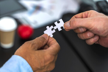 Close up hands holding jigsaw pazzle pieces , Business teamwork and partnership Concept