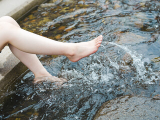 川の水を蹴って涼んでいる女性の足