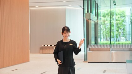 Asian female staff guiding in the lobby.