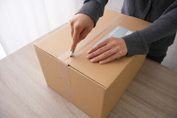 宅配便の荷物を受け取ったり、送ったりするために送り状を書く人