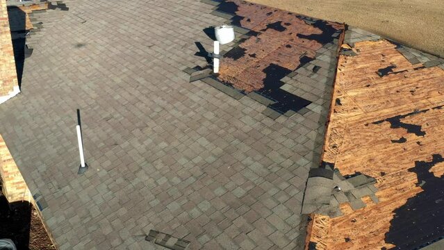 Tornado damage to roof with missing shingles, in need of repair