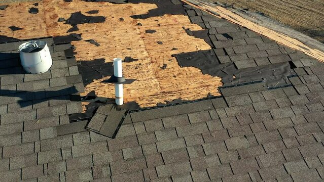 Tornado damage to roof with missing shingles, in need of repair