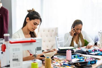 Diverse women fashion designer work design clothes in tailoring atelier. 