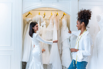 Beautiful bride discussing details with the wedding planner in studio. 