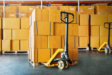 Package Boxes Stacked on Pallets with Hand Pallet Truck. Cartons, Cardboard Boxes. Storehouse, Distribution, Supply Chain. Supplies Warehouse Shipping.	
