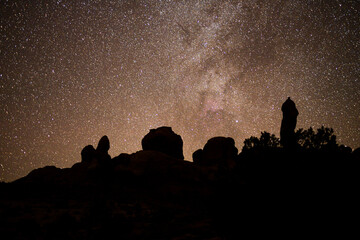 outlines of rock spires beneath the desert night sky.