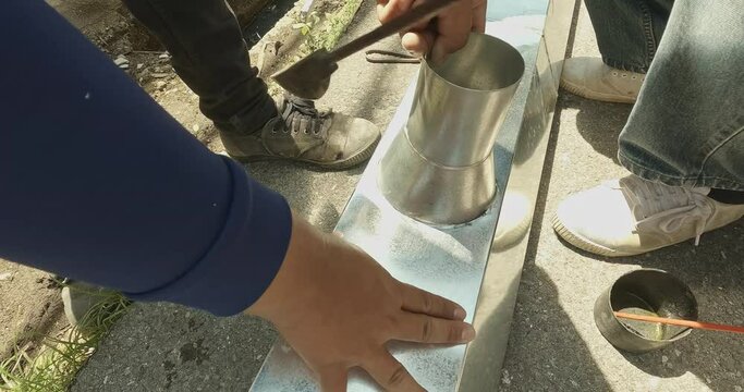 Zinc rain gutter welding by using soldering copper. Technician is welding aluminum pipe by using soldering copper.