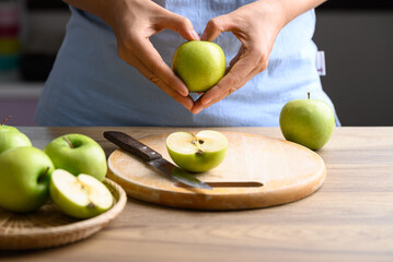 Hand holding green apple fruit with heart shape, Healthy eating