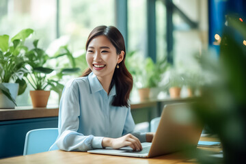 A happy Asian office girl working on her laptop in a cozy cafe, with a blurred background adding to the serene atmosphere. generative Ai.