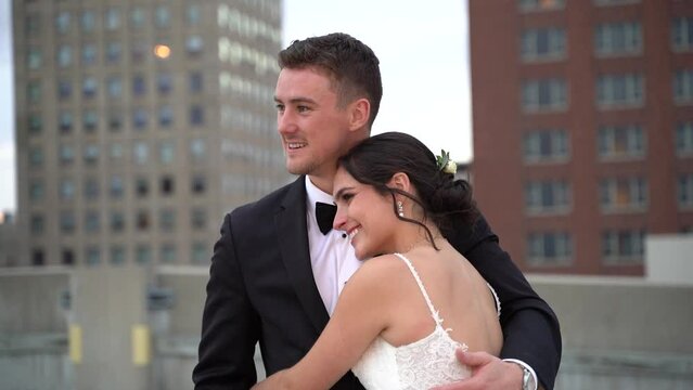 Beautiful newlyweds posing for pictures on top of a building