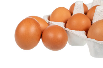 Eggs in an egg carton and eggs placed next to it on a white background