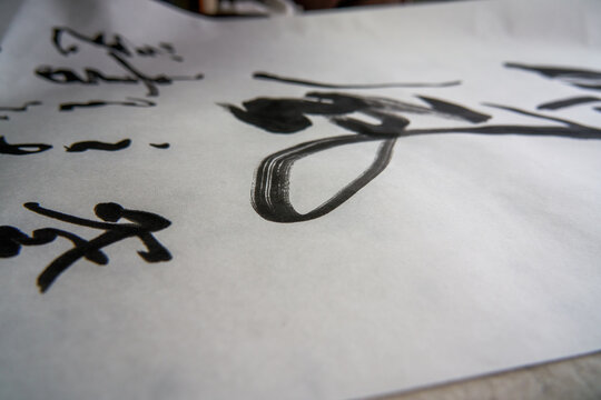 An old Chinese calligrapher is writing brush characters, creating Chinese calligraphy works.
Translation: Spring comes, the god of wind arrives.