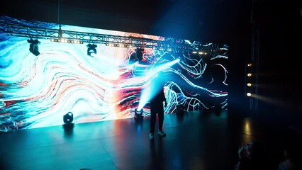 African-American Black rap artist performing his gig in front of a concert crowd on a stage of a large venue, surrounded by bright flashig lights