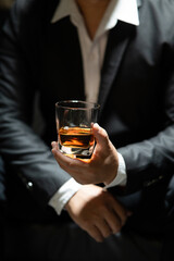 Businessman sitting Holding a Glass of Whiskey Drink Whiskey in the liquor store room