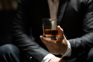 Businessman sitting Holding a Glass of Whiskey Drink Whiskey in the liquor store room