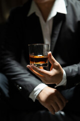Businessman sitting Holding a Glass of Whiskey Drink Whiskey in the liquor store room