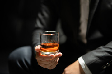 Businessman sitting Holding a Glass of Whiskey Drink Whiskey in the liquor store room