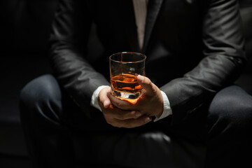 Businessman sitting Holding a Glass of Whiskey Drink Whiskey in the liquor store room