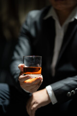 Businessman sitting Holding a Glass of Whiskey Drink Whiskey in the liquor store room