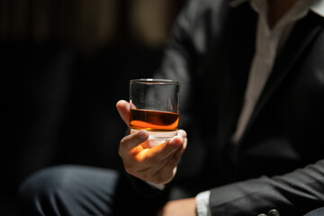 Businessman sitting Holding a Glass of Whiskey Drink Whiskey in the liquor store room