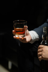 Businessman sitting Holding a Glass of Whiskey Drink Whiskey in the liquor store room