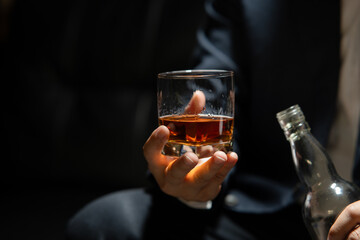 Businessman sitting Holding a Glass of Whiskey Drink Whiskey in the liquor store room