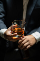 Businessman sitting Holding a Glass of Whiskey Drink Whiskey in the liquor store room