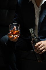 Businessman sitting Holding a Glass of Whiskey Drink Whiskey in the liquor store room