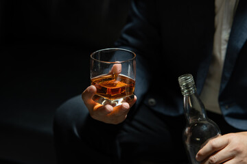Businessman sitting Holding a Glass of Whiskey Drink Whiskey in the liquor store room
