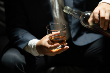 Businessman sitting Holding a Glass of Whiskey Drink Whiskey in the liquor store room