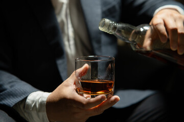 Businessman sitting Holding a Glass of Whiskey Drink Whiskey in the liquor store room